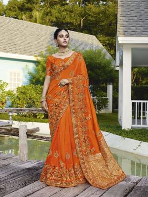 Get Ready For The Upcoming Wedding Season With This Heavy Designer Saree In Orange Color. This Pretty Heavy Embroidered Saree Is Fabricated On Satin Silk Paired With Art Silk Fabricated Blouse. It Has Very Pretty Detailed Embroidery Giving An Attractive Look. 
