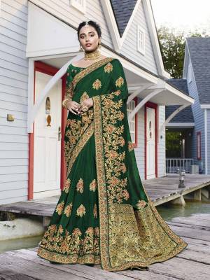 Get Ready For The Upcoming Wedding Season With This Heavy Designer Saree In Dark Green Color. This Pretty Heavy Embroidered Saree Is Fabricated On Satin Silk Paired With Art Silk Fabricated Blouse. It Has Very Pretty Detailed Embroidery Giving An Attractive Look. 