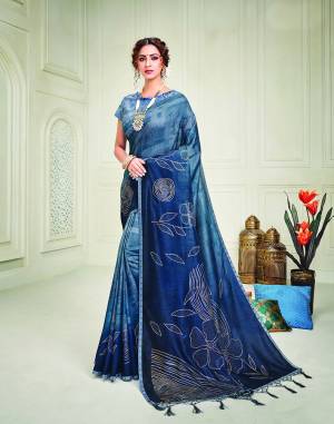 Exude charm like a royalty in this indogo blue shaded silk saree adorned with floral metallic embossed motifs and over 10,000 swarvoski crystals for that sheen. Pair it with a long maharani style necklace to add on to the royalty.