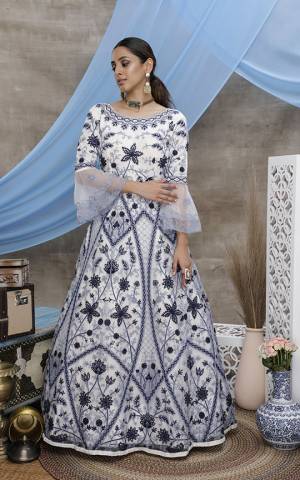 Grab This Beautiful Designer Semi-Stitched Suit In White Color Paired With White Dupatta. This Pretty Gown Style Suit Is Fabricated On Net Beautified With Thread Embroidery. 