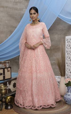 Grab This Beautiful Designer Semi-Stitched Suit In Peach Color Paired With White Dupatta. This Pretty Gown Style Suit Is Fabricated On Net Beautified With Thread Embroidery. 