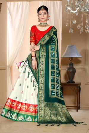 Go Colorful Wearing This Designer Silk Based Lehenga In Red, White And Dark Green Color. Its Pretty Blouse And Lehenga Are Fabricated On Satin Silk Paired With Bandhani Silk Dupatta. Its Fabric Is Durable, Light Weight And Easy To Carry Throughout The Gala. 