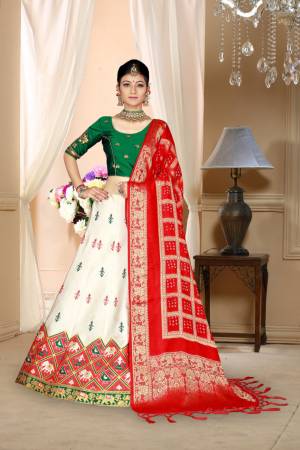 Go Colorful Wearing This Designer Silk Based Lehenga In Dark Green, White And Red Color. Its Pretty Blouse And Lehenga Are Fabricated On Satin Silk Paired With Bandhani Silk Dupatta. Its Fabric Is Durable, Light Weight And Easy To Carry Throughout The Gala. 