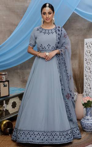Flaunt Your Rich And Elegant Taste Wearing This Designer Floor Length Suit In Grey Color. Its Top and dupatta Are Fabricated On Georgette Beautified With Detailed Minimal Embroidery. 