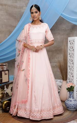 Flaunt Your Rich And Elegant Taste Wearing This Designer Floor Length Suit In Pastel Peach Color. Its Top Is Fabricated On Georgette Paired With Net Fabricated Dupatta, Beautified With Detailed Minimal Embroidery. 