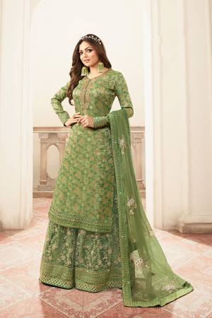 You Will Definitely Earn Lots Of Compliments Wearing This Heavy Designer Sharara Suit In Green Color. Its Top Is Fabricated Jacquard Silk Paired With Net Fabricated Embroidered Bottom And Net Dupatta. 