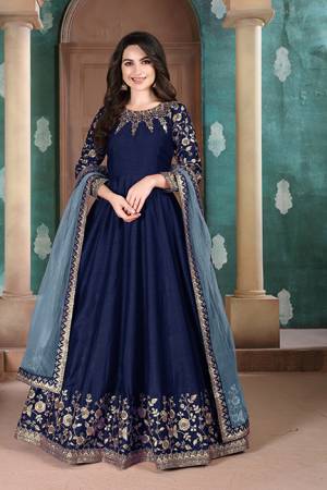 Here Is A Designer Floor Length Suit In Royal Blue Color Paired With Grey Colored Dupatta. Its Pretty Embroidered Top Is Fabricated on Slub Silk Paired With Santoon Bottom and Net Fabricated Dupatta. Buy Now.