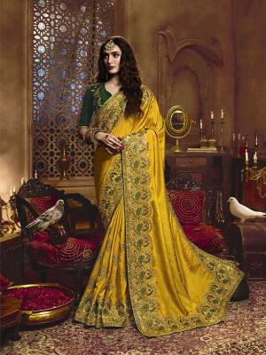 Flaunt Your Rich And Elegant In This Pretty Yellow Colored Heavy Embroidered Saree Paired With Green Colored Blouse. This Saree Is Fabricated On Satin Silk Paired With Art Silk Fabricated Blouse. Buy This Heavy Designer Saree Now. 