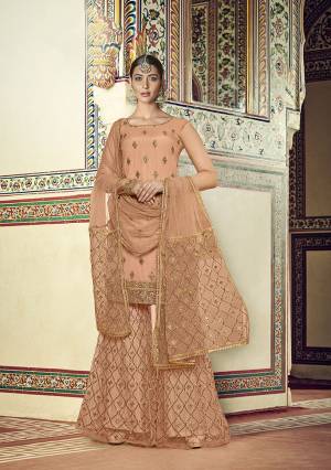 You Will Definitely Earn Lots Of Compliments Wearing This Heavy Designer sharara Suit In Light Peach Color. Its Top, Bottom and Dupatta Are Net Based Beautified With Heavy Embroidery Work. 