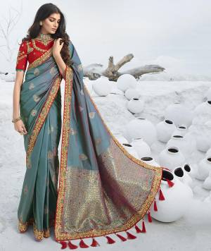 Add This Beautiful Designer Saree To Your Wardrobe For The Upcoming Wedding and Festive Season In Blue Color Paired With Contrasting Red Colored Blouse. This Saree Is Fabricated On Jacquard Silk Paired With Art Silk Fabricated Blouse. 