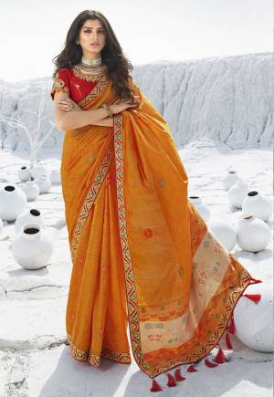 Catch All The Limelight At The Next Wedding You Attend Wearing This Designer Orange Colored Saree Paired With Contrasting Red Colored Blouse. This Saree Is Jacquard Silk Based Paired With Art Silk Fabricated Blouse. 