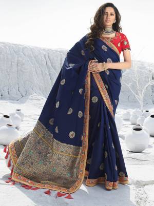 Add This Beautiful Designer Saree To Your Wardrobe For The Upcoming Wedding and Festive Season In Navy Blue Color Paired With Contrasting Red Colored Blouse. This Saree Is Fabricated On Jacquard Silk Paired With Art Silk Fabricated Blouse. 
