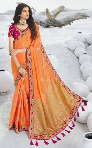 Catch All The Limelight At The Next Wedding You Attend Wearing This Designer Orange Colored Saree Paired With Contrasting Magenta Pink Colored Blouse. This Saree Is Jacquard Silk Based Paired With Art Silk Fabricated Blouse. 