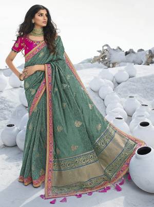 Here Is A Very Pretty Designer Saree In Lovely Teal Green Color Paired With Contrasting Dark Pink Colored Blouse, This Saree Is Fabricated On Jacquard Silk Paired With Art Silk Fabricated Blouse. Its Rich Silk Fabric Gives A Royal Look To Your Personality. 