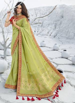 Add This Beautiful Designer Saree To Your Wardrobe For The Upcoming Wedding and Festive Season In Light Green Color Paired With Contrasting Red Colored Blouse. This Saree Is Fabricated On Jacquard Silk Paired With Art Silk Fabricated Blouse. 