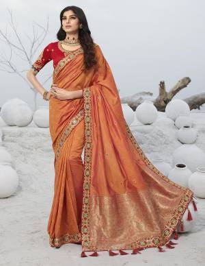 Catch All The Limelight At The Next Wedding You Attend Wearing This Designer Orange Colored Saree Paired With Contrasting Red Colored Blouse. This Saree Is Jacquard Silk Based Paired With Art Silk Fabricated Blouse. 