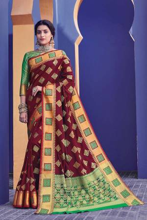 This Festive Season, Adorn A Proper Traditional Look Wearing This Saree In Maroon Color Paired With Green Colored Blouse. This Saree And Blouse Are Fabricated On Banarasi Silk Beautified With Weave All Over. 