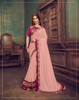 It is The season of frills, fancy and fabulousness . A simple soft pink saree uplifted with a small embroidered border, a designer blouse and those double-layered frills - A designer piece well-put together for your classic tastes.