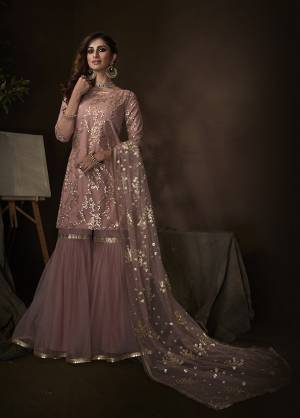 Shine Bright Wearing This Lovely Designer Sharara Suit In All Over Dusty Pink Color. Its Top, Bottom And Dupatta Are Fabricated On Net Beautified With Attractive Embroidery Work. Buy This Pretty Suit Now.