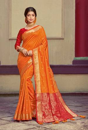 Here Is A Pretty Silk Based Saree In Orange Colored Paired With Contrasting Red colored Blouse. This Saree and Blouse Are Fabricated On Handloom Silk Beautified With Weave All Over. It Is Light In Weight And Easy To Carry All Day Long. 