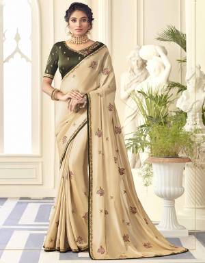Simple And Elegant Looking Embroidered Designer Saree Is Here In Cream Color Paired With Contrasting Dark Green Colored Blouse. This Saree Is Fabricated On Satin Silk Paired With Art Silk Fabricated Blouse. 
