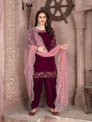 Here Is A Very Pretty Designer Suit In Maroon Color Paired With Paired With Peach Colored Dupatta. Its Embroidered Top Is Fabricated On Velvet Paired With Santoon Bottom And Net Fabricated Dupatta. This Pretty Suit Is Light In Weight And Easy To Carry All Day Long. 