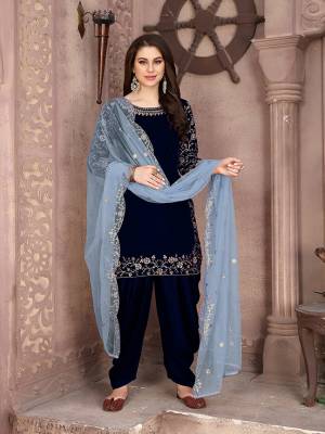 Here Is A Very Pretty Designer Suit In Navy Blue Color Paired With Paired With Baby Blue Colored Dupatta. Its Embroidered Top Is Fabricated On Velvet Paired With Santoon Bottom And Net Fabricated Dupatta. This Pretty Suit Is Light In Weight And Easy To Carry All Day Long. 
