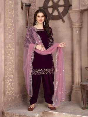 Here Is A Very Pretty Designer Suit In Purple Color Paired With Paired With Pink Colored Dupatta. Its Embroidered Top Is Fabricated On Velvet Paired With Santoon Bottom And Net Fabricated Dupatta. This Pretty Suit Is Light In Weight And Easy To Carry All Day Long. 