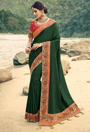 Celebrate This Festive Season In This Heavy Designer Saree In Dark Green Color Paired With Red Colored Blouse. This Saree And Blouse Are Silk Based Beautified With Pretty Attractive Embroidery. Buy Now.