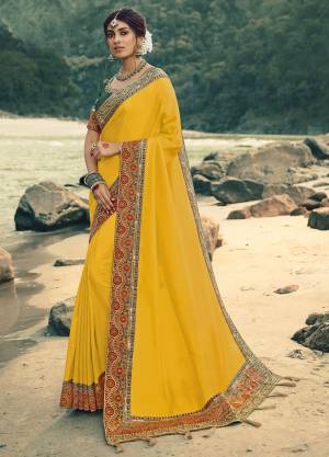 Celebrate This Festive Season In This Heavy Designer Saree In Yellow Color Paired With Dark Green Colored Blouse. This Saree And Blouse Are Silk Based Beautified With Pretty Attractive Embroidery. Buy Now.