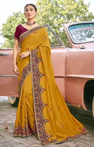 Look Attractive Wearing This Musturd Yellow Colored Saree Paired With Maroon Colored Blouse.  This Heavy Designer Saree Is Silk Based Which Gives A Rich Look To Your Personality. Buy This Pretty Saree Now.